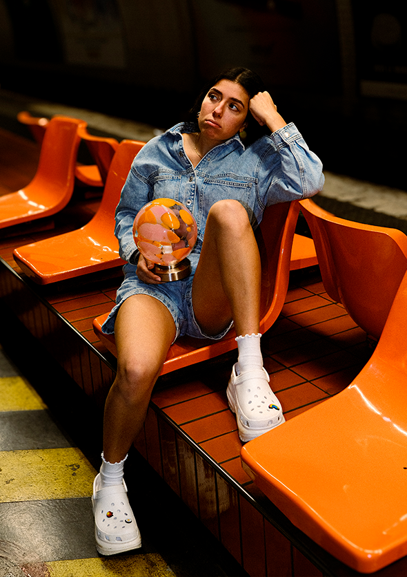 Femme assise sur siège orange quai de métro
