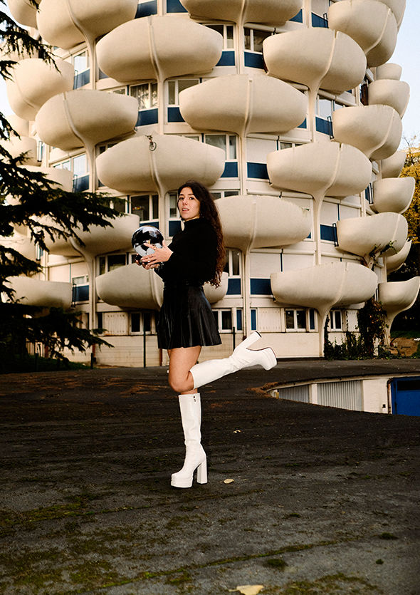 Femme debout en jupe tenant une lampe dans les mains